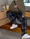 Men’s black drawstring plaid relaxed-fit trousers.