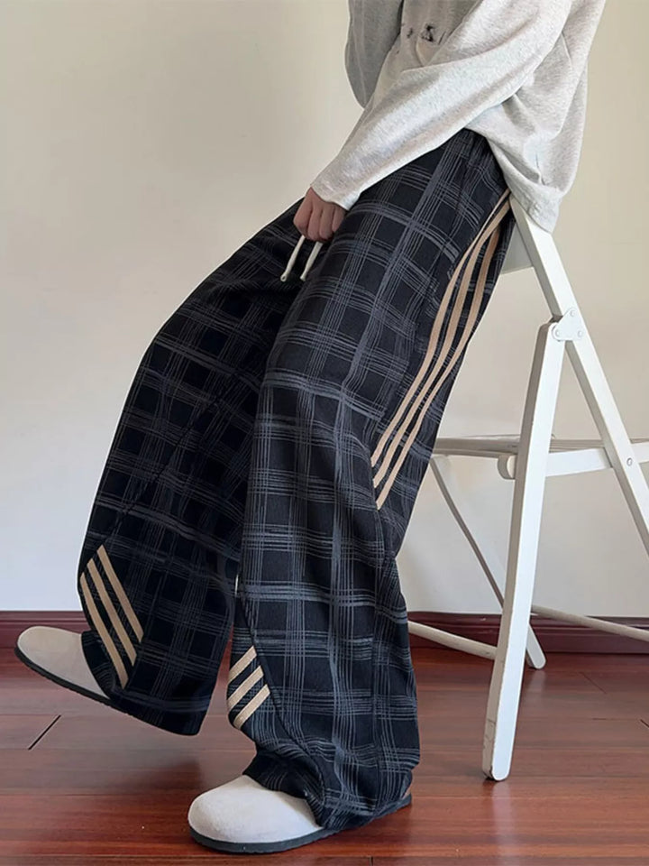 Men’s plaid wide-leg pants with side stripes.