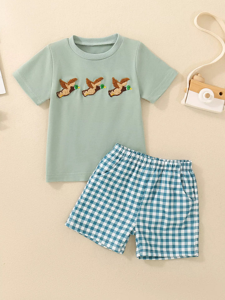 Duck-embroidered children’s T-shirt with green gingham shorts.
