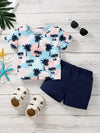 Tropical palm-print children’s T-shirt with dark blue shorts.