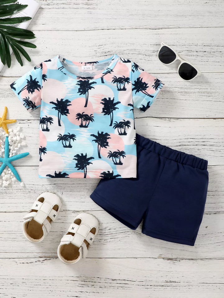 Tropical palm-print children’s T-shirt with dark blue shorts.