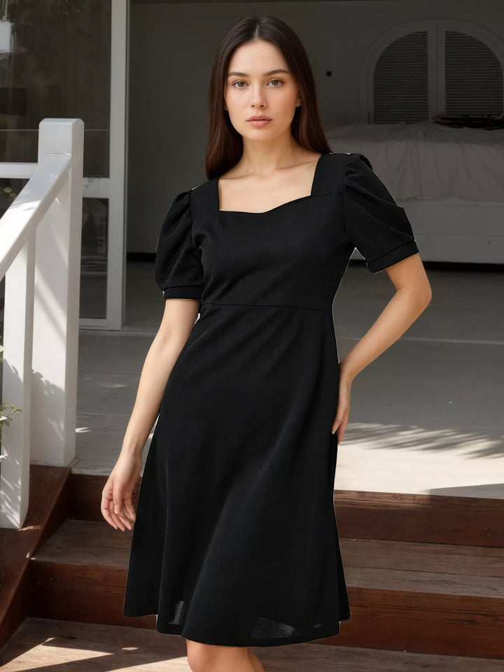 Black square-neck puff-sleeve mini dress with bow-back detail.