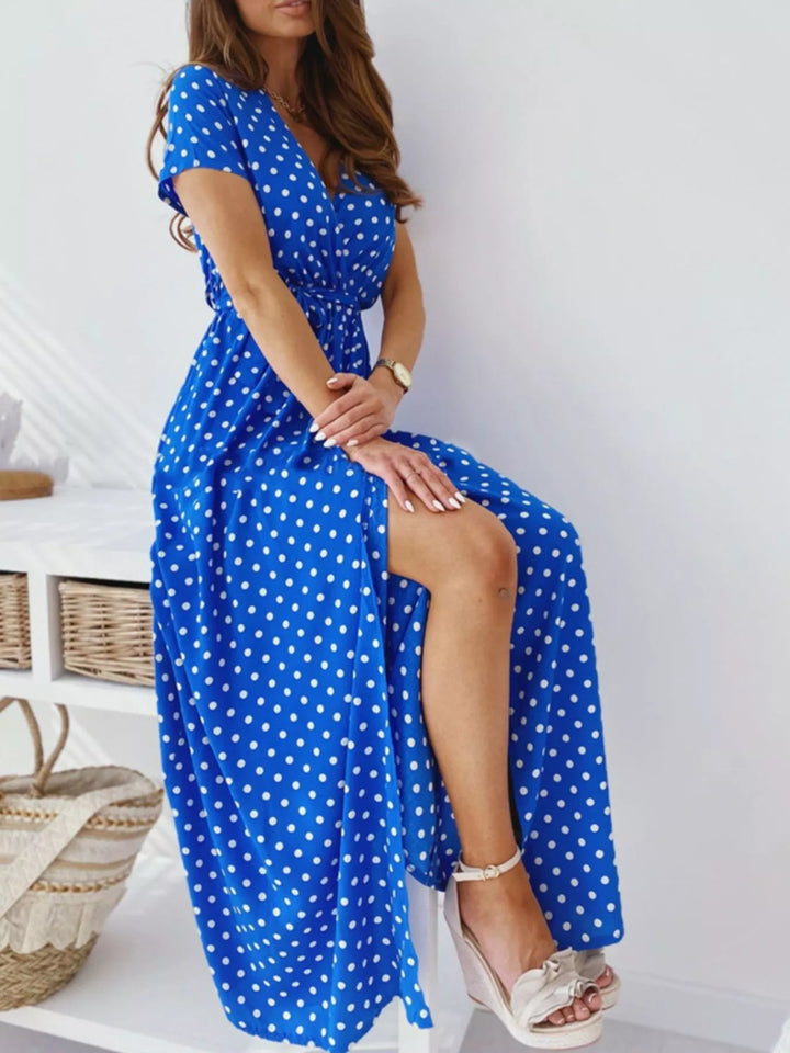 Royal blue polka-dot surplice maxi dress with side slit.
