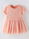 Peach printed tulle-layered children’s dress.