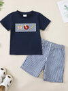 Blue children’s embroidered T-shirt with striped shorts.